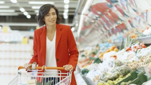 young woman browsing the produce aisle at a grocery store