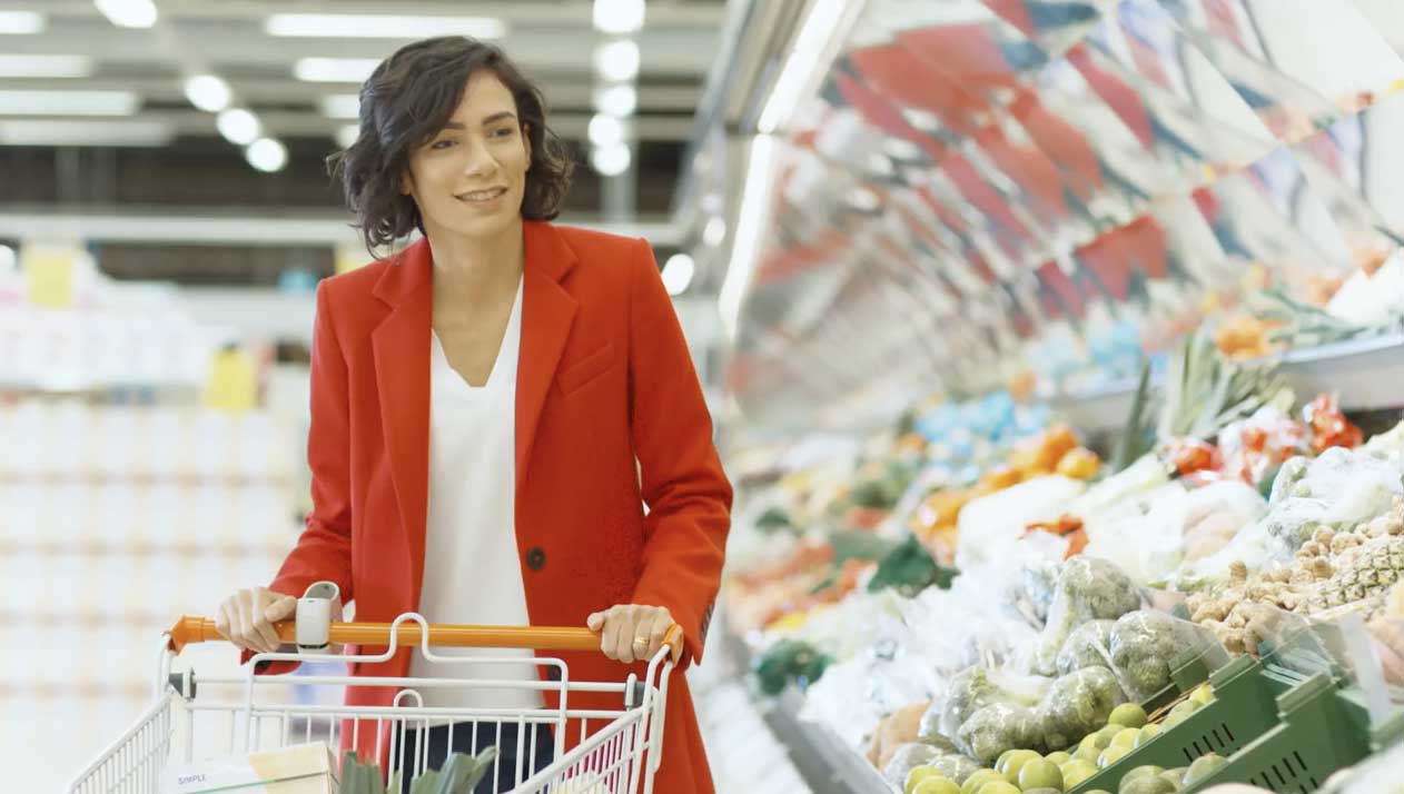 young woman browsing the produce aisle at a grocery store