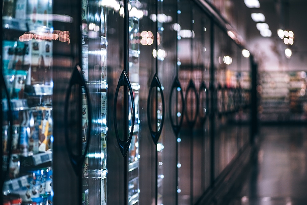 row of coolers in the frozen aisle of a grocery store