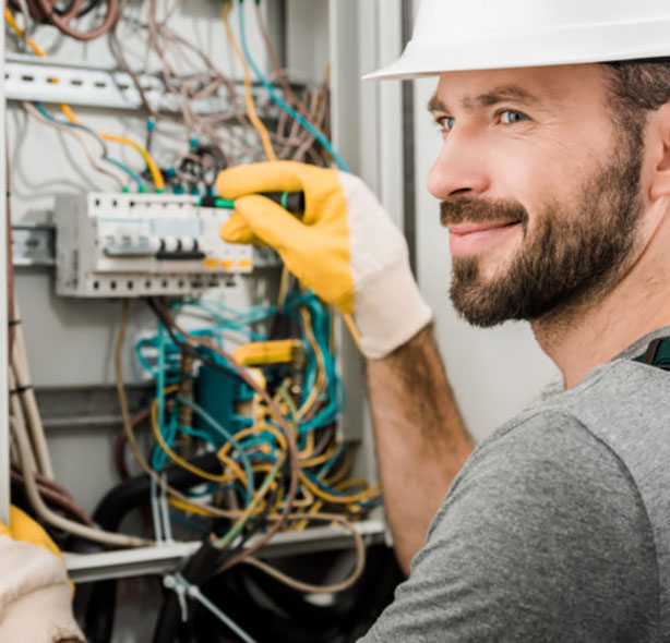 electrician conducting maintenance on open panel