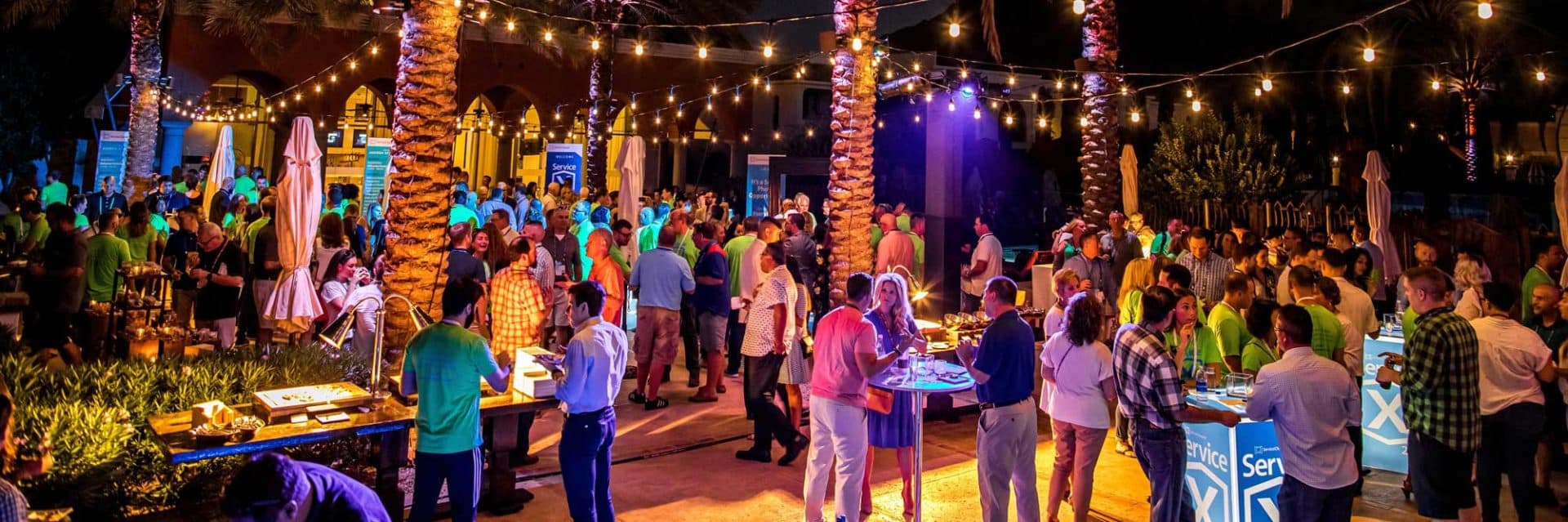 ServiceChannel post-conference mixer for professionals, scattered across a wide courtyard adorned with exotic trees