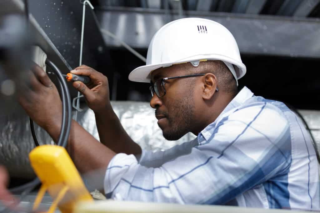 Construction worker repairing wires.