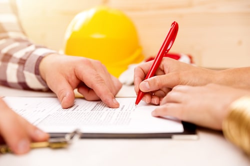 Woman signing construction contract with contractor to build a house