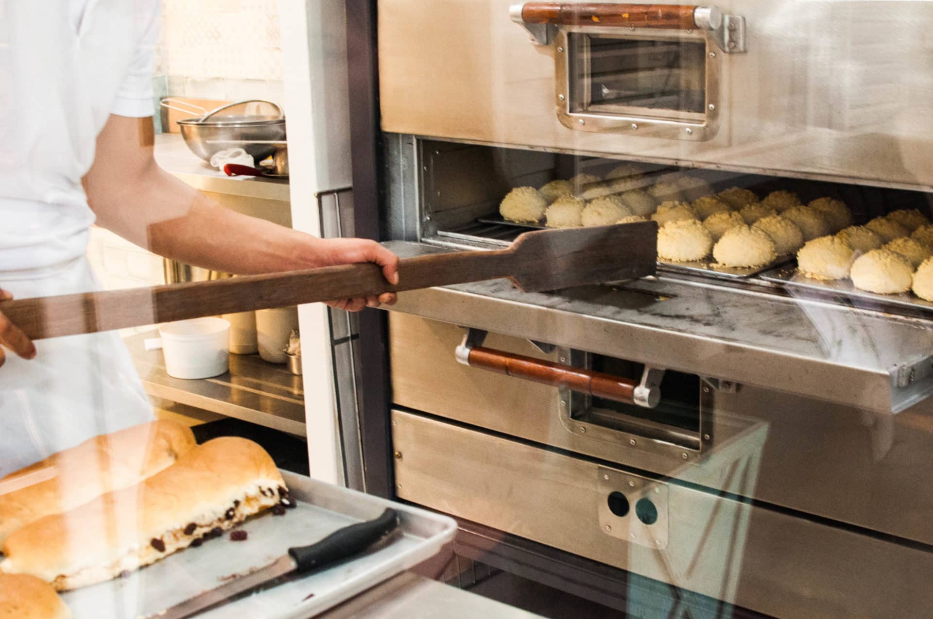 baker taking treats out of an industrial oven