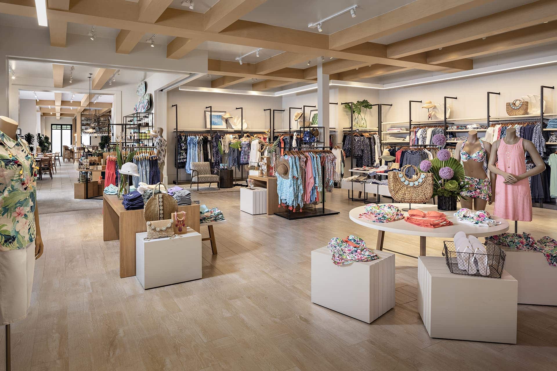 Tommy Bahama store interior with women's and men's wear displayed across racks, shelves and tables