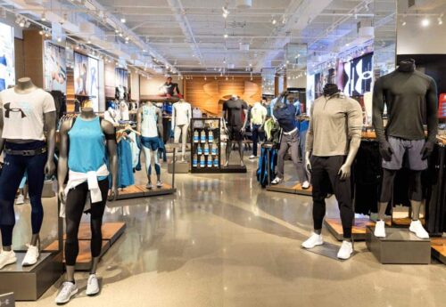 Under Armour store interior with athletic wear for men and women on display on mannequins and shelves