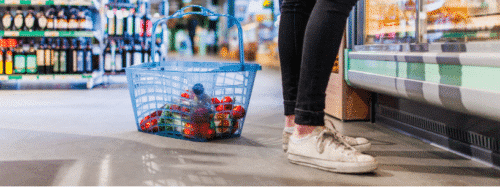 grocery basket filled with assorted goods on the store floor