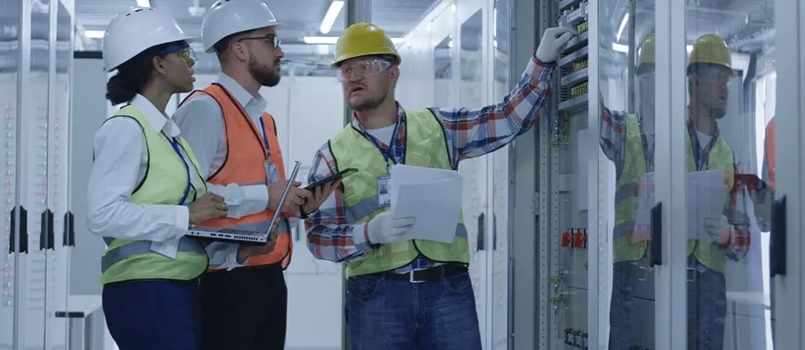 three maintenance professionals evaluating an industrial processor