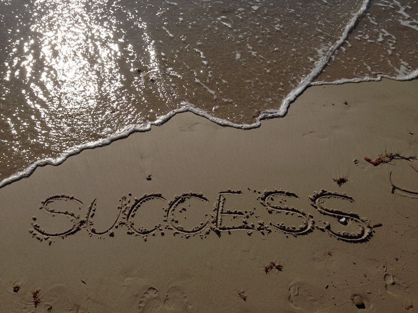 the word success written on a beach pictured aerially