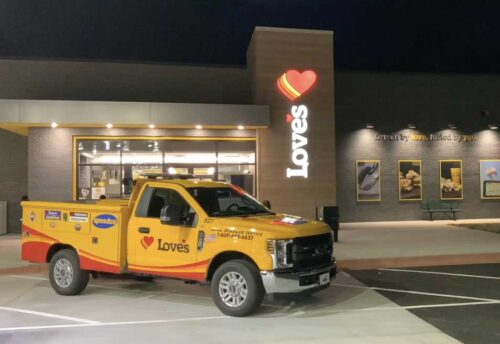 Love's corporate truck featured in front of Love's storefront at night