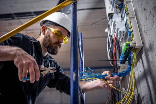 electrician works on an electrical switchboard