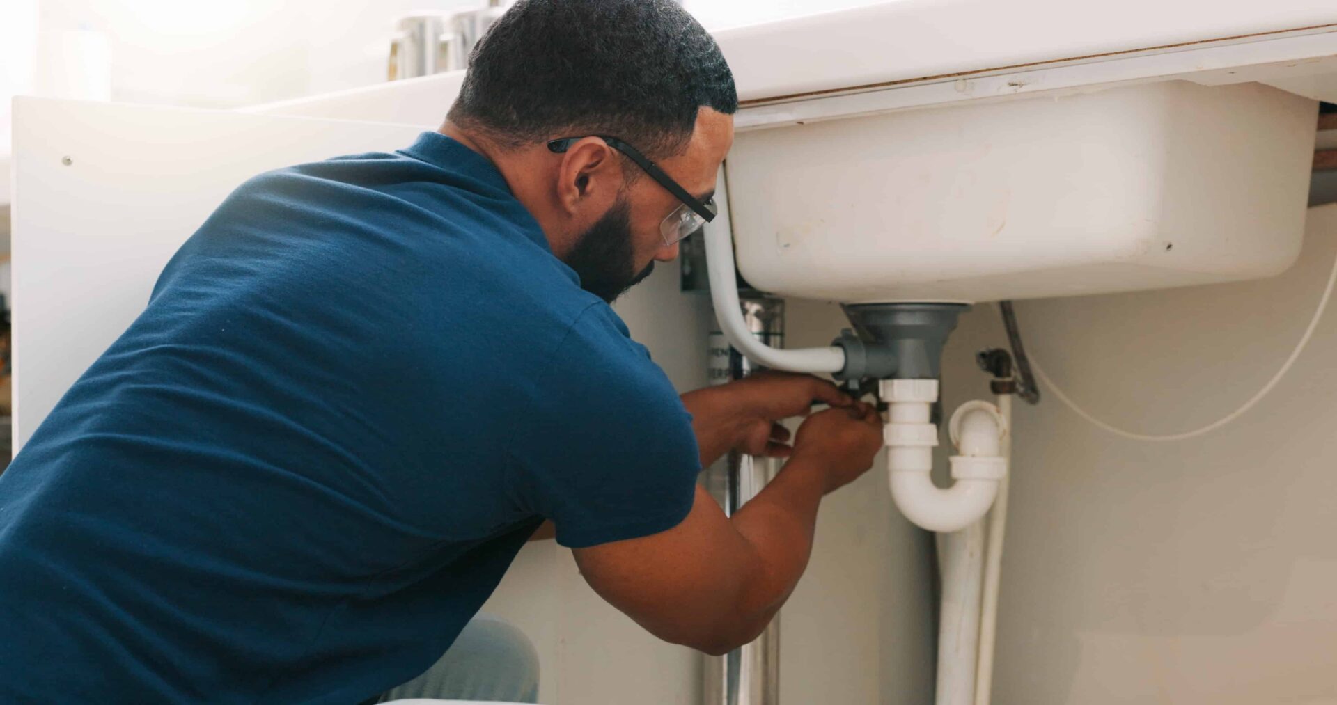 Plumber fixing under sink water system