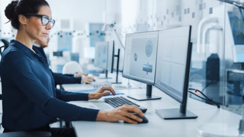 Industrial Engineer solving problems, working on a computer to determine scrap rates.
