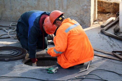 workers servicing and maintaining sewer lines