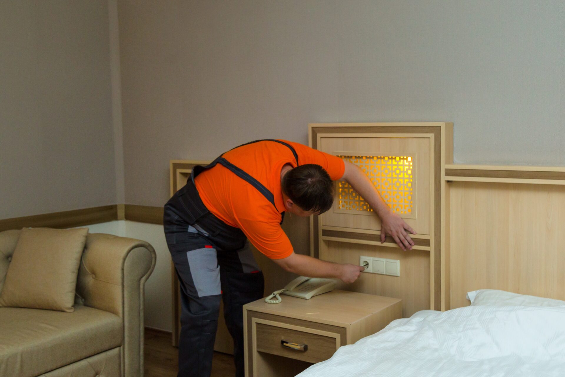 Maintenance-worker-repairing-electric-socket-hotel-room